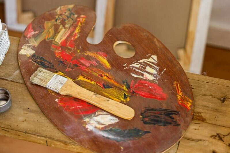 Vibrant palette and brushes alongside blank canvases create an artistic mood.